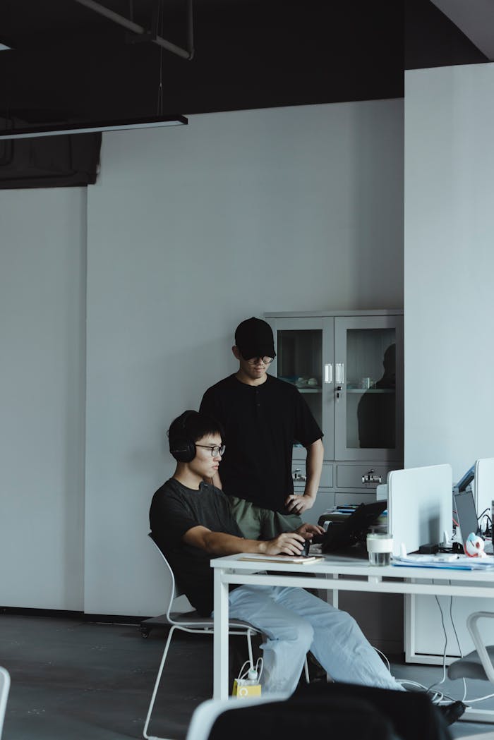 Two colleagues collaborating at a computer in a modern, minimalist office.